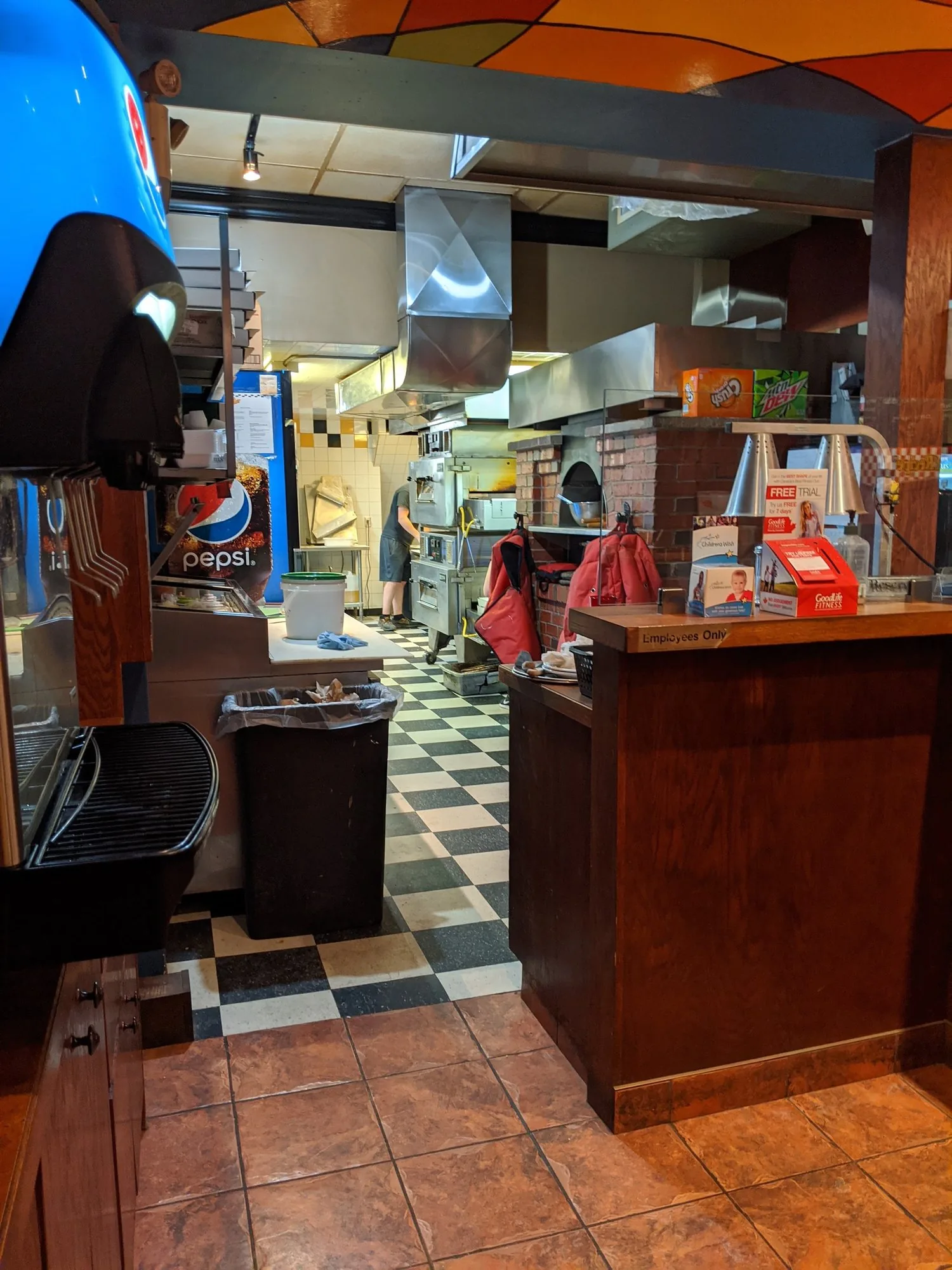 Inside the front door: the wood counter, the black and white checker floor and the open kitchen behind
