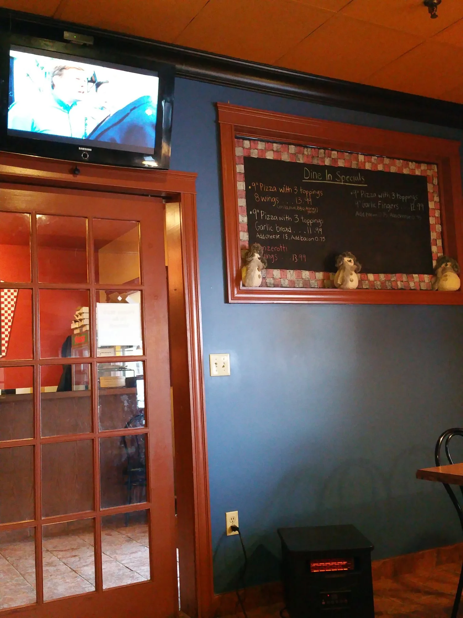 The dining room with its blue wall, French doors and a chalkboard in a wood frame
