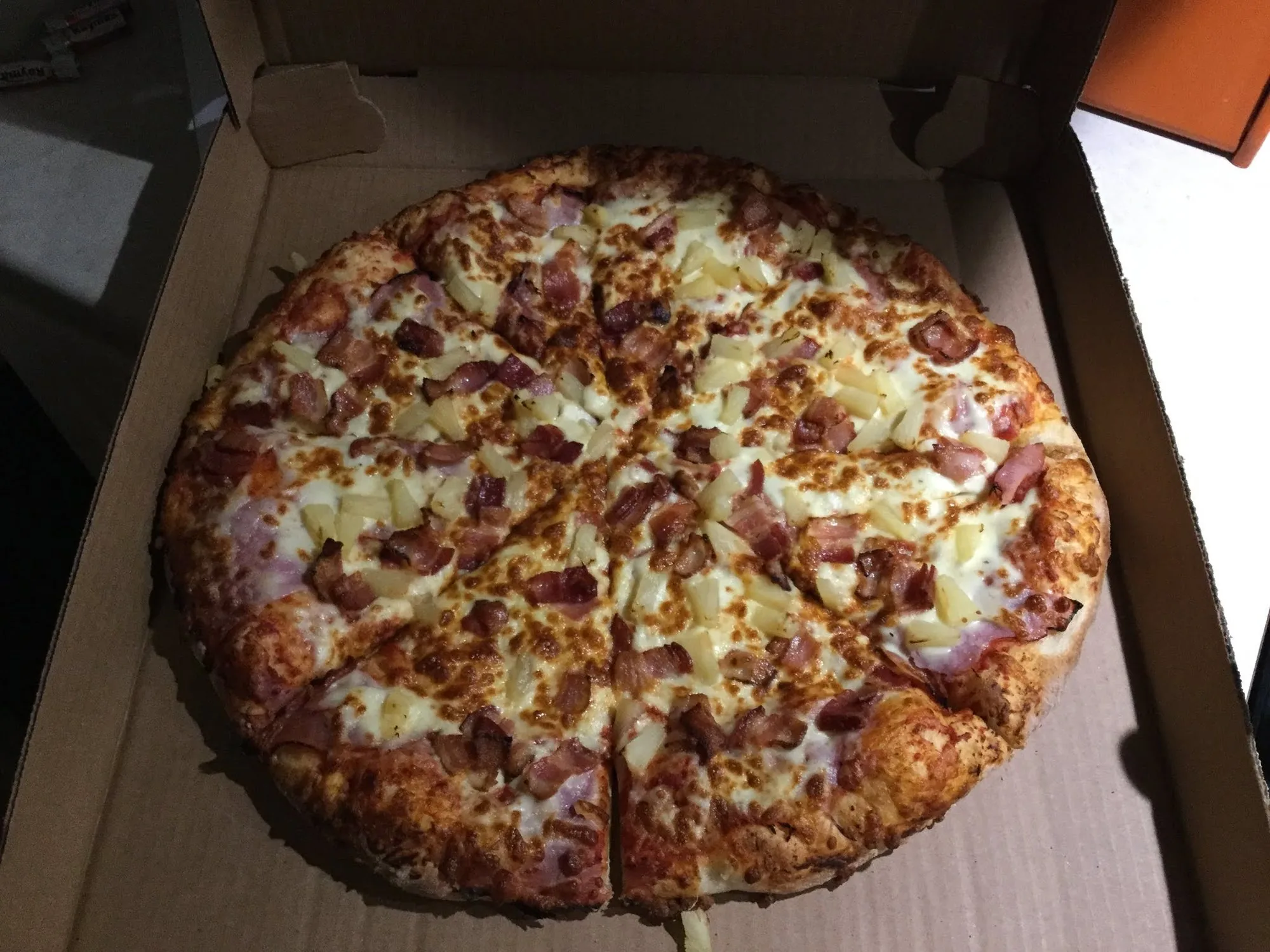 A whole pizza in an open Little Christo's box